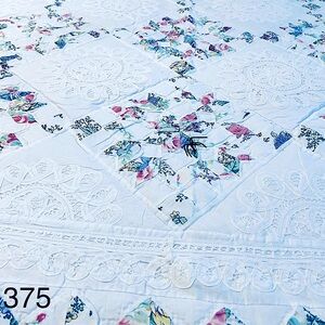 White and Blue Quilted Bedding with Subtle Floral Design